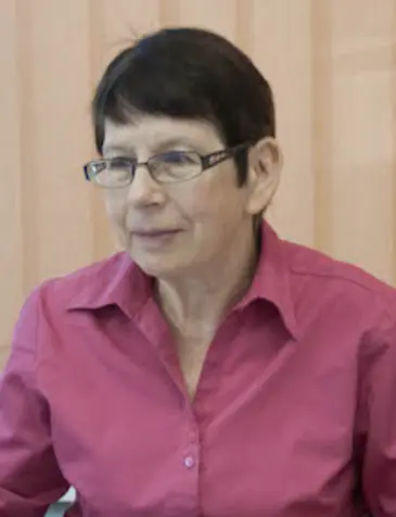 A person wearing glasses and a pink shirt

Description automatically generated